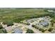 An overhead shot features homes in a neighborhood adjacent to a verdant conservation area with a winding road at 16211 Oak Breeze Ct, Clermont, FL 34711
