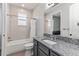 Bathroom featuring a gray vanity with granite countertops, a tub, and tile walls at 16211 Oak Breeze Ct, Clermont, FL 34711