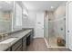 Modern bathroom featuring double vanity sinks, a glass-enclosed shower, and neutral tones at 16211 Oak Breeze Ct, Clermont, FL 34711