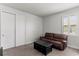 Bright bedroom with plantation shutters, a leather sofa, and closet with sliding doors at 16211 Oak Breeze Ct, Clermont, FL 34711