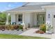 Inviting front entrance features a green door, stylish lighting, and a beautifully landscaped garden at 16211 Oak Breeze Ct, Clermont, FL 34711