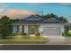 Charming single-story home featuring a well-manicured lawn, lovely landscaping, and a two-car garage at 16211 Oak Breeze Ct, Clermont, FL 34711