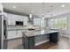 Modern kitchen featuring stainless steel appliances, granite countertops, a large island, and white cabinetry at 16211 Oak Breeze Ct, Clermont, FL 34711