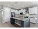 Modern kitchen featuring stainless steel appliances, granite countertops, a large island, and white cabinetry at 16211 Oak Breeze Ct, Clermont, FL 34711