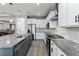 Modern kitchen featuring stainless steel appliances, granite countertops, a large island, and white cabinetry at 16211 Oak Breeze Ct, Clermont, FL 34711