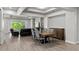 Bright living room and dining area with wood flooring, modern finishes, and tray ceiling detail at 16211 Oak Breeze Ct, Clermont, FL 34711