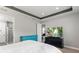 Well-lit main bedroom with stylish furniture, a tray ceiling, a TV, and an attached bathroom at 16211 Oak Breeze Ct, Clermont, FL 34711