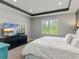 Comfortable main bedroom featuring a modern TV, shuttered windows, and stylish decor; large bed at 16211 Oak Breeze Ct, Clermont, FL 34711