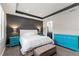 Bright main bedroom with a tray ceiling, a large bed, and elegant furniture; bathroom entrance visible at 16211 Oak Breeze Ct, Clermont, FL 34711