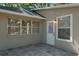 View of back of house with stone patio, window, and door to backyard at 1663 Markel Dr. Dr, Winter Garden, FL 34787