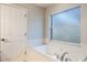 Bathroom featuring a large tub under a window and a tiled wall at 1663 Markel Dr. Dr, Winter Garden, FL 34787