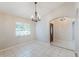 Bright dining room with tiled floors, a decorative chandelier, and a view into the entryway through an arched doorway at 1663 Markel Dr. Dr, Winter Garden, FL 34787