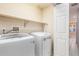 Modern laundry room featuring a white washer and dryer with a shelf above at 1663 Markel Dr. Dr, Winter Garden, FL 34787