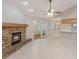 Open living space showcasing tile flooring, a stone fireplace, and an archway into a bright kitchen area at 1663 Markel Dr. Dr, Winter Garden, FL 34787