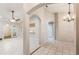 Open concept living area featuring tile floors, arched doorways, and views into an adjacent kitchen and enclosed lanai at 1663 Markel Dr. Dr, Winter Garden, FL 34787