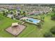 Aerial shot of community pool area and playground equipment amidst greenery and neighboring residences at 169 Jensen Dr, Groveland, FL 34736