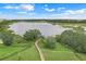 Aerial view of a lakefront property with a wooden bridge leading to a charming gazebo, showcasing a tranquil waterfront setting at 169 Jensen Dr, Groveland, FL 34736