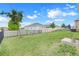 Spacious backyard featuring a lawn area and fence for privacy, set against a blue sky at 169 Jensen Dr, Groveland, FL 34736