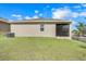 Exterior view of home's backyard, showcasing the screen door, lawn, and exterior finish at 169 Jensen Dr, Groveland, FL 34736