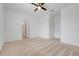Neutral carpeted bedroom with ceiling fan, closet and entry door at 169 Jensen Dr, Groveland, FL 34736