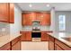 Close up of a kitchen featuring granite countertops, stainless steel appliances, and cherry cabinets at 169 Jensen Dr, Groveland, FL 34736