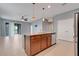 Kitchen island with sink and dishwasher open to living area and stainless steel refrigerator at 169 Jensen Dr, Groveland, FL 34736