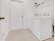 Bright laundry room featuring white appliances, white door and a wire shelf for added storage at 169 Jensen Dr, Groveland, FL 34736