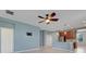 Open-concept living room featuring tile floors and a ceiling fan adjacent to the kitchen at 169 Jensen Dr, Groveland, FL 34736