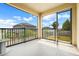 Covered patio with black metal railing offering outdoor living space and neighborhood views at 169 Jensen Dr, Groveland, FL 34736