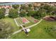 Aerial view of recreation area includes bocce ball and basketball courts with mature trees at 2112 Saint Ives Ct, Clermont, FL 34711