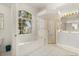 Bright bathroom with a soaking tub, walk-in shower and a large window at 2112 Saint Ives Ct, Clermont, FL 34711