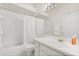 Bright white bathroom with tub-shower, white vanity, and large mirror at 2112 Saint Ives Ct, Clermont, FL 34711