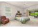 Cozy bedroom with a floral bedspread, view of backyard, and sliding glass door access to the lanai at 2112 Saint Ives Ct, Clermont, FL 34711