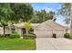 Charming single-story home featuring a well-manicured lawn, mature trees, and a spacious three-car garage at 2112 Saint Ives Ct, Clermont, FL 34711