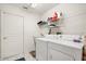 Functional laundry room featuring a washer, dryer, utility sink and storage shelving at 2112 Saint Ives Ct, Clermont, FL 34711