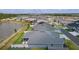 Aerial view of a residential neighborhood, showing fenced yards, manicured lawns and a tranquil lake nearby at 2129 Landrea Loop, The Villages, FL 32163