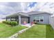 Spacious backyard with well manicured lawn and a screened patio featuring outdoor seating at 2129 Landrea Loop, The Villages, FL 32163
