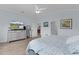 A bedroom features neutral-colored decor, wood-look tile floors, and a view into the rest of the home at 2129 Landrea Loop, The Villages, FL 32163