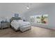 A bedroom features a tray ceiling, a large window, wood-look tile floors, and neutral-colored decor at 2129 Landrea Loop, The Villages, FL 32163