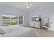 A bedroom features neutral-colored decor, wood-look tile floors, and a view of the property at 2129 Landrea Loop, The Villages, FL 32163