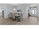 Dining room with chandelier, wood floors, art, and open access to the kitchen and front entry at 2129 Landrea Loop, The Villages, FL 32163