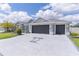 Spacious driveway featuring a palm tree insignia that leads to a charming single Gathering home with a three car garage at 2129 Landrea Loop, The Villages, FL 32163