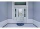 Elegant front door with glass and sidelights, set in a light gray entryway of a modern home at 2129 Landrea Loop, The Villages, FL 32163