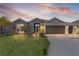 Beautiful single Gathering home with a well manicured lawn and landscaping with a two car garage at sunset at 2129 Landrea Loop, The Villages, FL 32163