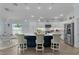 A kitchen features a large island with countertop seating, modern lighting, and stainless steel appliances at 2129 Landrea Loop, The Villages, FL 32163
