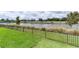 Beautiful lake view behind a fence and a well manicured backyard lawn at 2129 Landrea Loop, The Villages, FL 32163