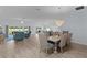 Open concept living room featuring wood floors, dining area with chandelier, and large windows at 2129 Landrea Loop, The Villages, FL 32163