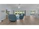 Open concept living room featuring wood floors, lanai access, and light airy aesthetic at 2129 Landrea Loop, The Villages, FL 32163