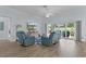Open living room with wood floors, comfortable seating, TV, and sliding glass doors to outdoor space at 2129 Landrea Loop, The Villages, FL 32163