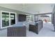 An outdoor patio features comfortable seating and sliding glass doors with views of a pond and outdoor spaces at 2129 Landrea Loop, The Villages, FL 32163